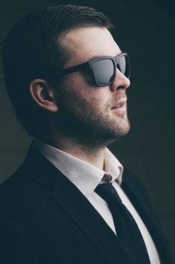 karanlık bir odada güneş gözlüklü adam