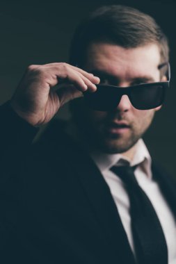 güneş gözlüklü adam biraz karanlık odada indirdi