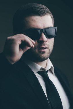 güneş gözlüklü adam biraz karanlık odada indirdi