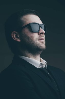 karanlık bir odada güneş gözlüklü adam