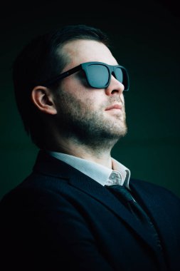 karanlık bir odada güneş gözlüklü adam