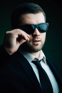 güneş gözlüklü adam biraz karanlık odada indirdi