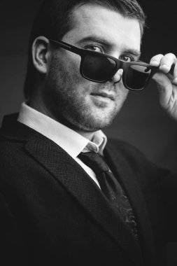 güneş gözlüklü adam biraz karanlık odada indirdi