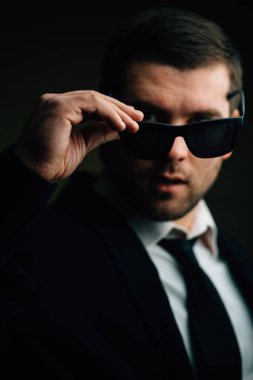 güneş gözlüklü adam biraz karanlık odada indirdi