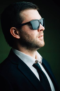 karanlık bir odada güneş gözlüklü adam