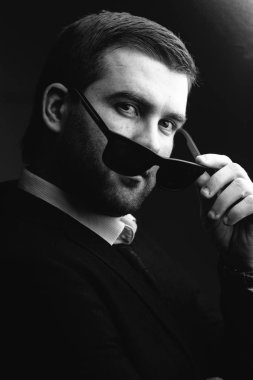 güneş gözlüklü adam biraz karanlık odada indirdi