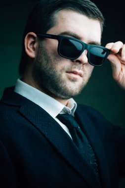 güneş gözlüklü adam biraz karanlık odada indirdi