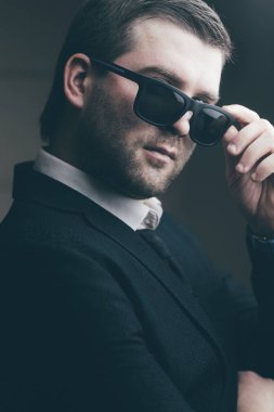 güneş gözlüklü adam biraz karanlık odada indirdi