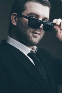 güneş gözlüklü adam biraz karanlık odada indirdi