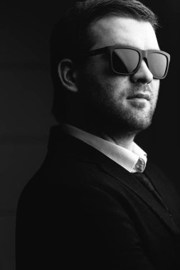 karanlık bir odada güneş gözlüklü adam