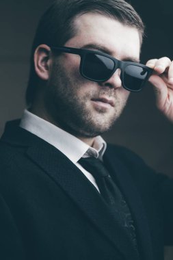 güneş gözlüklü adam biraz karanlık odada indirdi