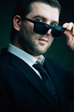 güneş gözlüklü adam biraz karanlık odada indirdi