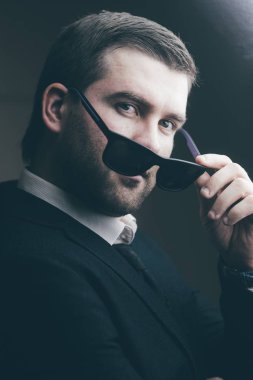 güneş gözlüklü adam biraz karanlık odada indirdi