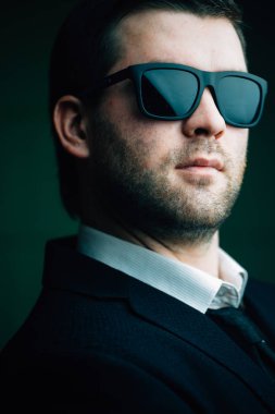 karanlık bir odada güneş gözlüklü adam