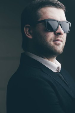 karanlık bir odada güneş gözlüklü adam