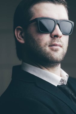 karanlık bir odada güneş gözlüklü adam