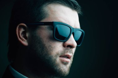 karanlık bir odada güneş gözlüklü adam