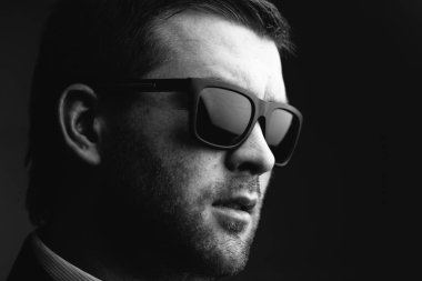 karanlık bir odada güneş gözlüklü adam