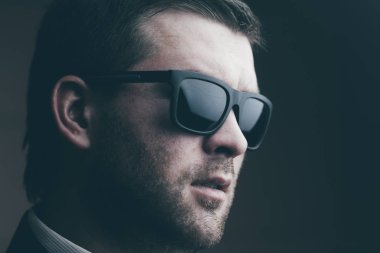 karanlık bir odada güneş gözlüklü adam