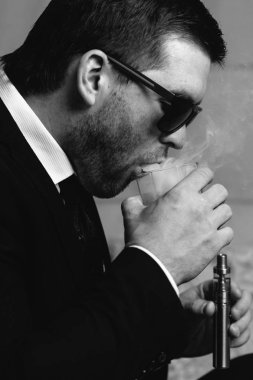 adam bir bardak viski ve elektronik sigara ile