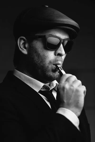 时尚男士太阳镜和皮帽抽烟 — 图库照片