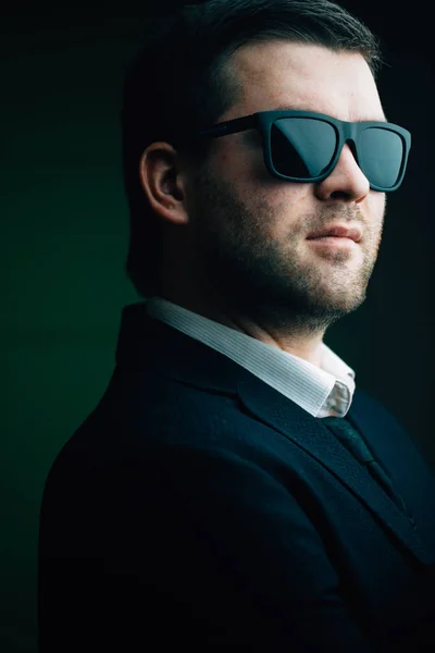 Человек в солнцезащитных очках в темной комнате — стоковое фото