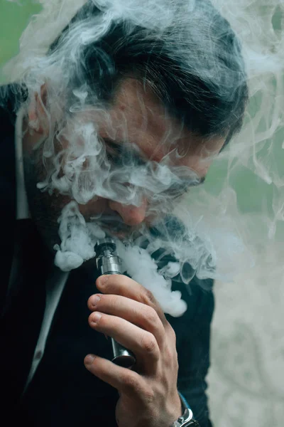 Businessman smoking electronic cigarette — Stock Photo, Image