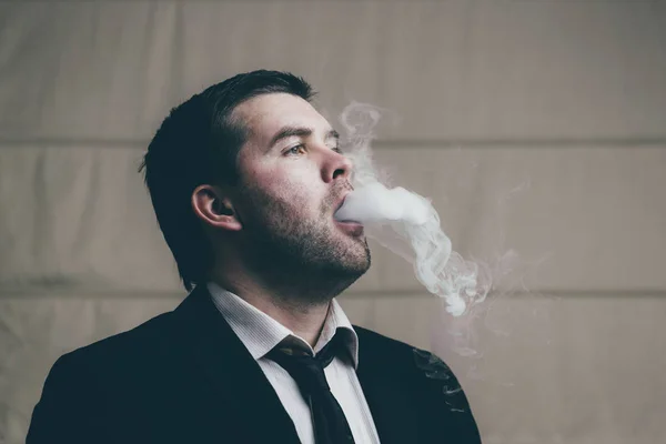 Geschäftsmann atmet Zigarettenrauch aus — Stockfoto