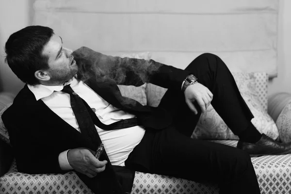 Hombre de negocios mintiendo y fuma un cigarrillo electrónico —  Fotos de Stock