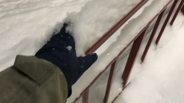 Hand in glove throw off the snow from the railing — Stock Video