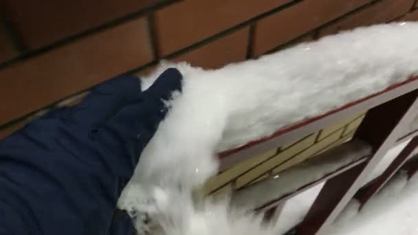 Χέρι με γάντι ρίξει έξω από το χιόνι από το κιγκλίδωμα — Αρχείο Βίντεο