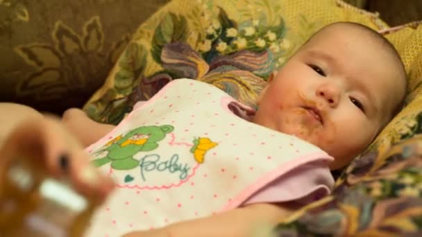 Madre alimenta a su pequeño bebé puré con cuchara — Vídeo de stock