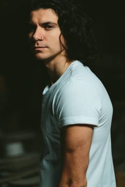 karanlık bir arka plan üzerinde uzun saçlı acımasız adam