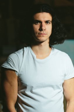 karanlık bir arka plan üzerinde uzun saçlı acımasız adam