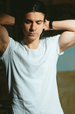 karanlık bir arka plan üzerinde uzun saçlı acımasız adam