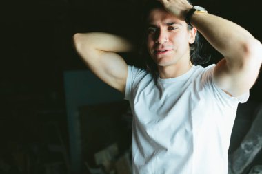 karanlık bir arka plan üzerinde uzun saçlı acımasız adam