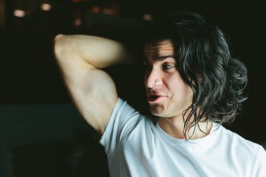 beyaz bir T-shirt hamming uzun saçlı adam