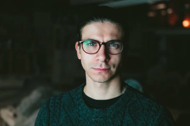 karanlık bir arka plan üzerinde gözlüklü genç yakışıklı adam