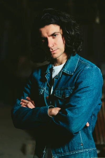 Bell'uomo con i capelli lunghi bruna in una giacca di jeans — Foto Stock