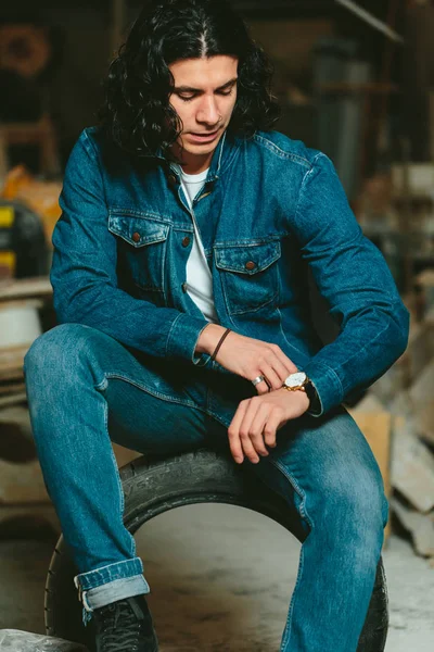 Красивый мужчина с длинными волосами брюнетка в джинсовой куртке — стоковое фото