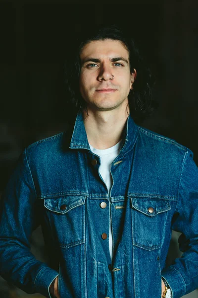 handsome man with long hair brunette in a denim jacket