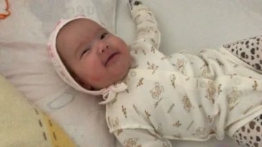 yatakta yatan ve yakın çekim gülümseyen küçük bebek