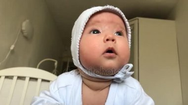 Küçük bebek başını ve dünya onun etrafında inceleyerek kaldırmalar