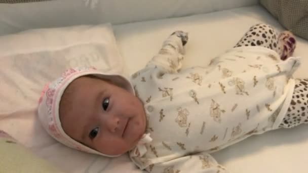 Yatakta yatan ve yakın çekim gülümseyen küçük bebek — Stok video