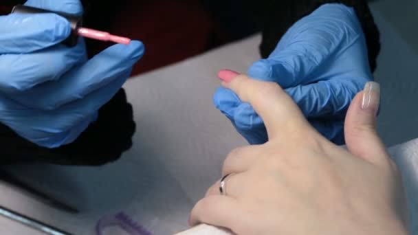 Manicura de mujer. aplicar esmalte de uñas rosa en la uña — Vídeo de stock