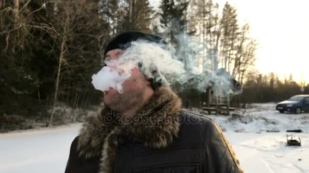 Adam yavaş kışın bulutlar beyaz kalın duman doğada exhales — Stok video