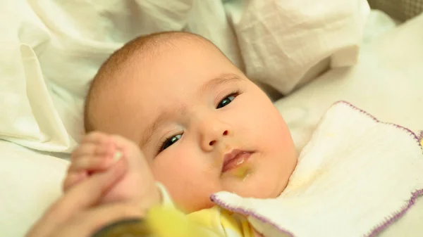 Mãe alimenta seu pequeno filho purê de bebê com colher — Fotografia de Stock