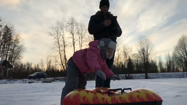 Liten flicka och gummi uppblåsbara snow tube — Stockvideo