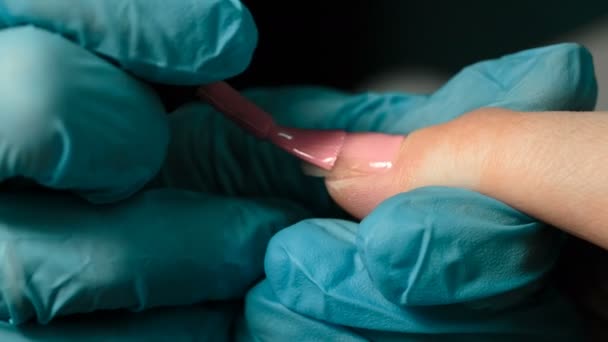 Нанесення рожевого лаку для нігтів на ніготь — стокове відео