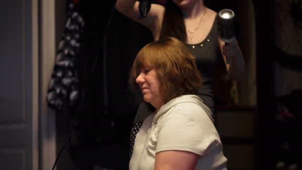 Friseur trocknet Frau mittleren Alters den Föhn — Stockvideo